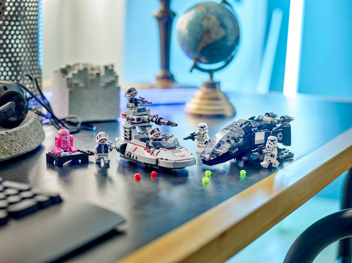 Toy space ships and figures on a desk with a blurred background