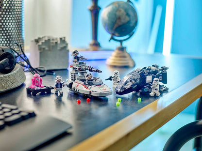 Toy space ships and figures on a desk with a blurred background