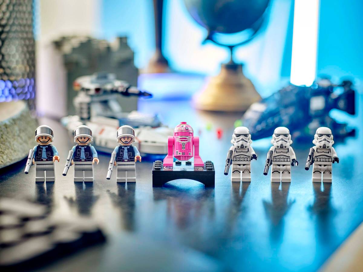 LEGO figures on a desk with a pink robot in the center